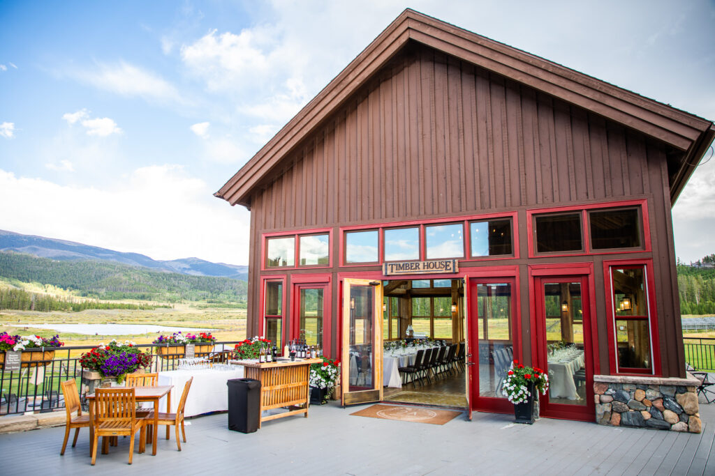 Timber House event space with tables, bar, and scenic mountain views.
