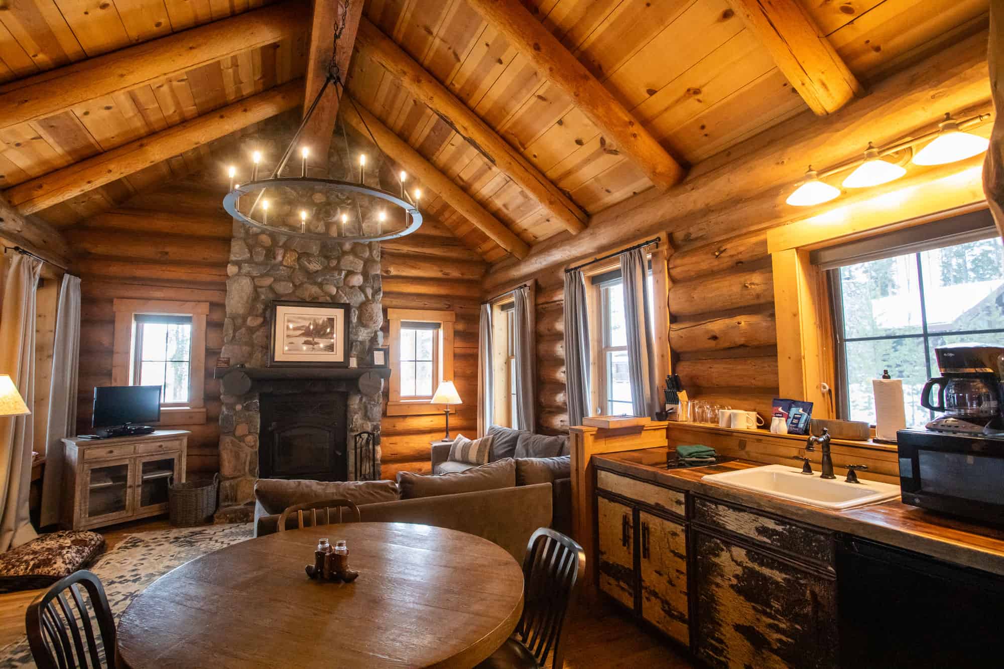 Cozy log cabin living room with stone fireplace and wooden accents at Devil's Thumb Ranch.