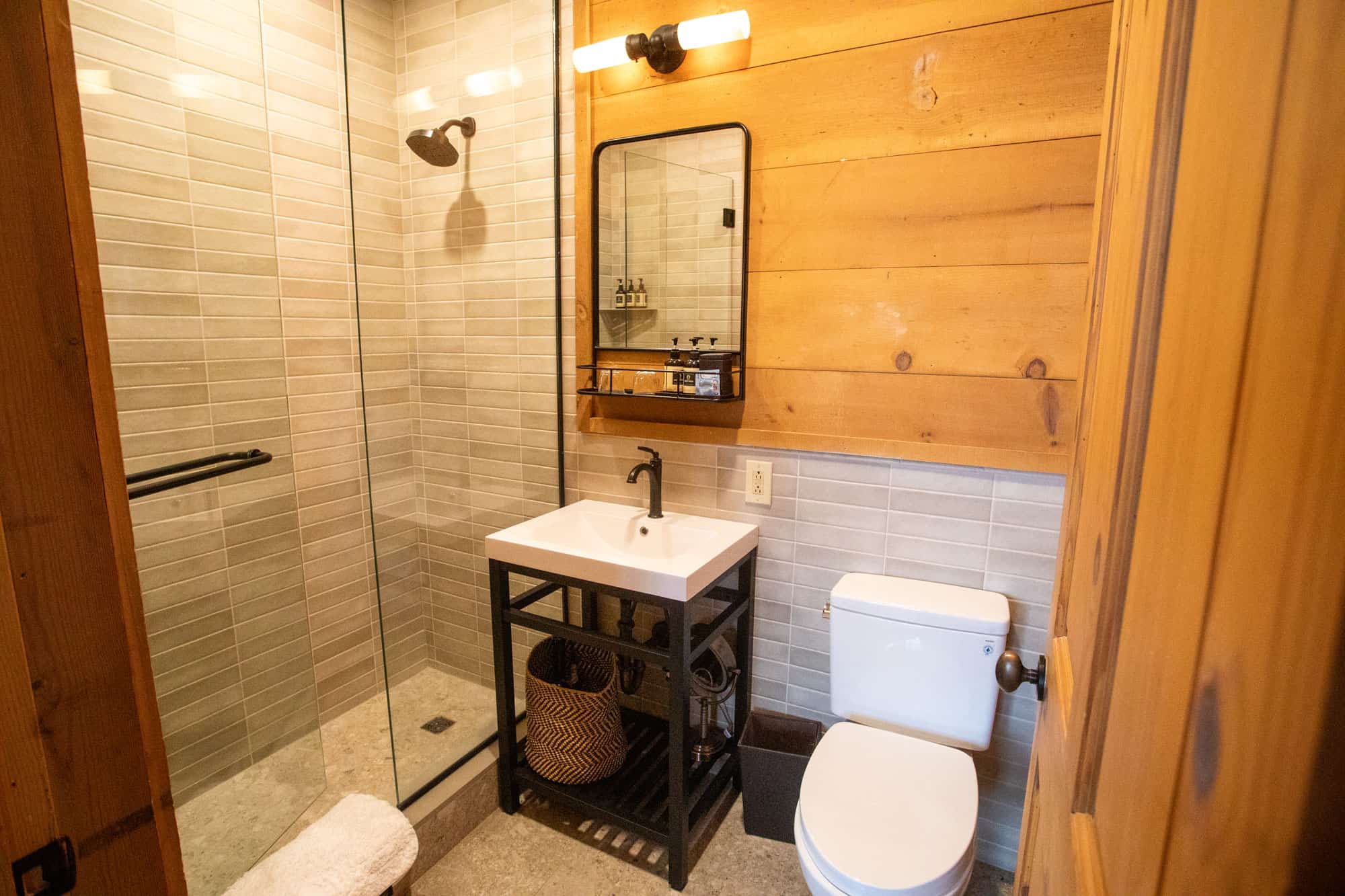 Bathroom with walk-in shower, wooden accents, and modern fixtures.