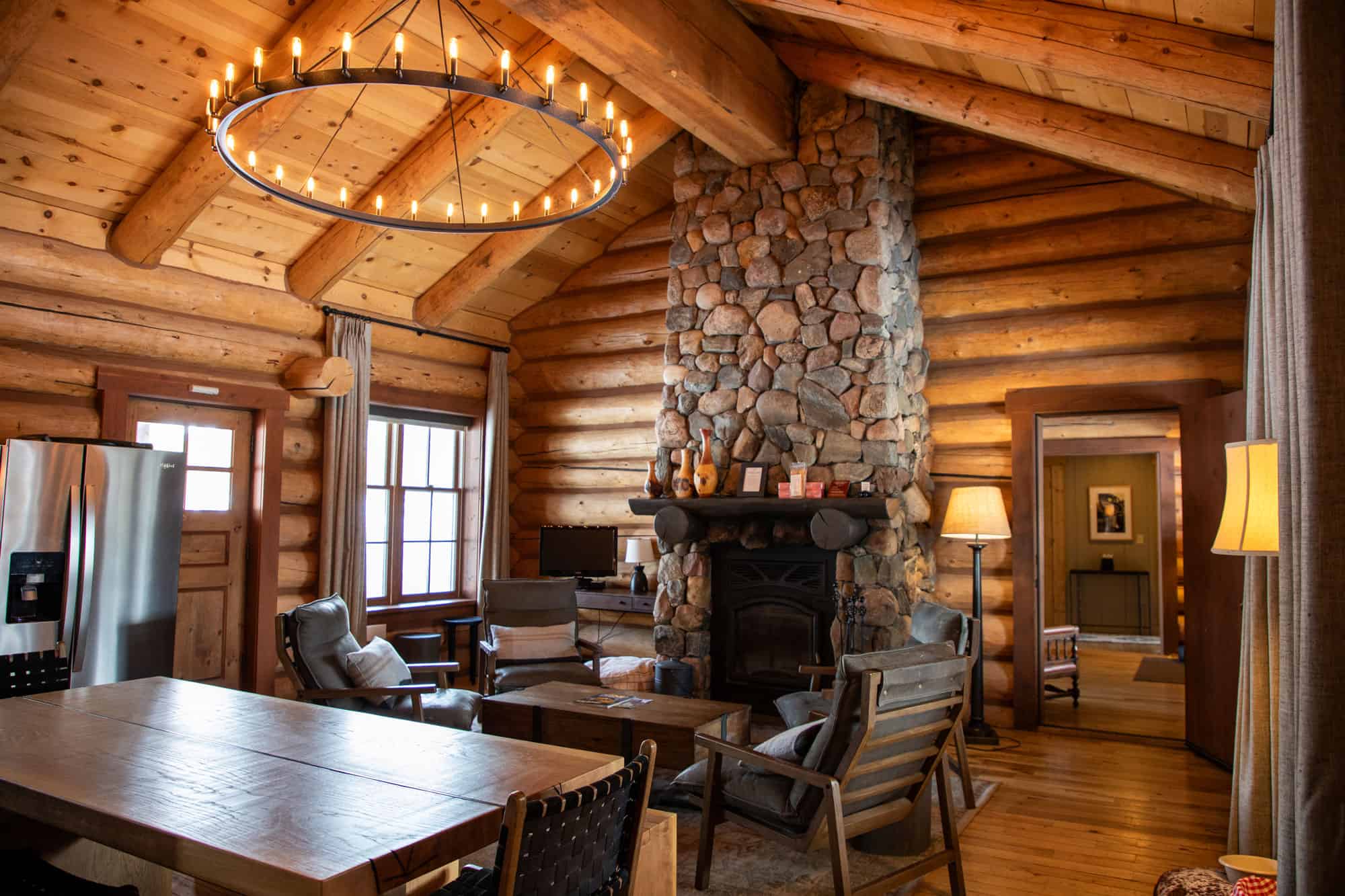 Warm log cabin interior with stone fireplace and rustic decor at Devil's Thumb Ranch.