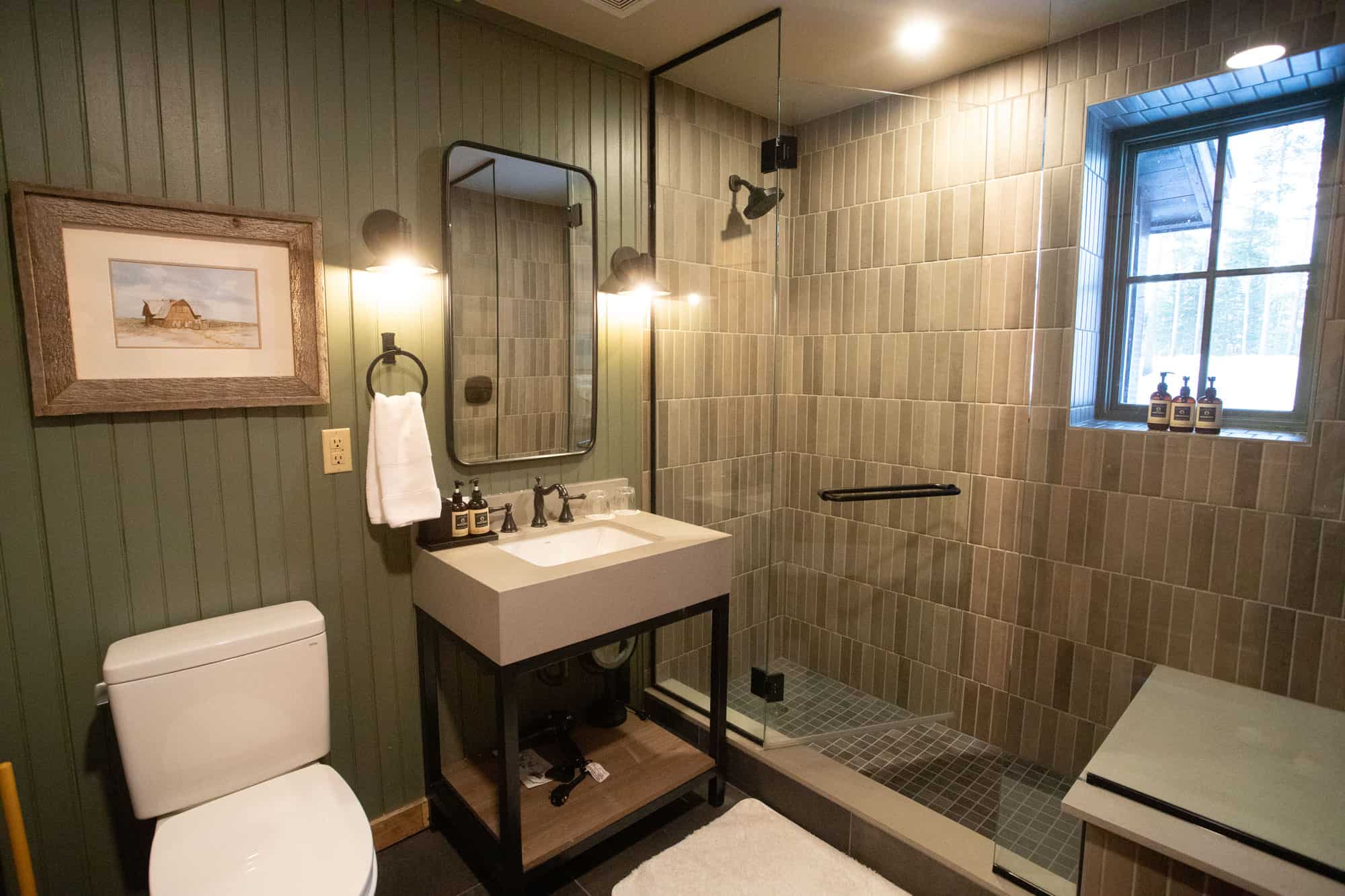 Bright bathroom featuring a walk-in shower, vanity, and window at Devil's Thumb Ranch Resort & Spa.