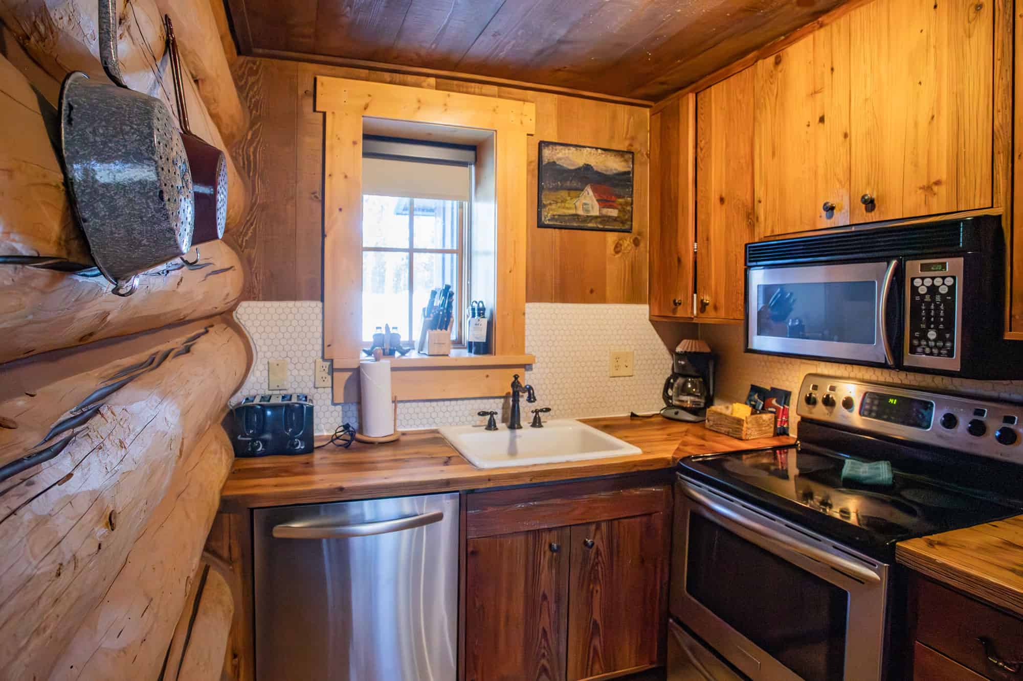 Cozy rustic kitchen at Devil's Thumb Ranch with wooden cabinets and modern appliances.