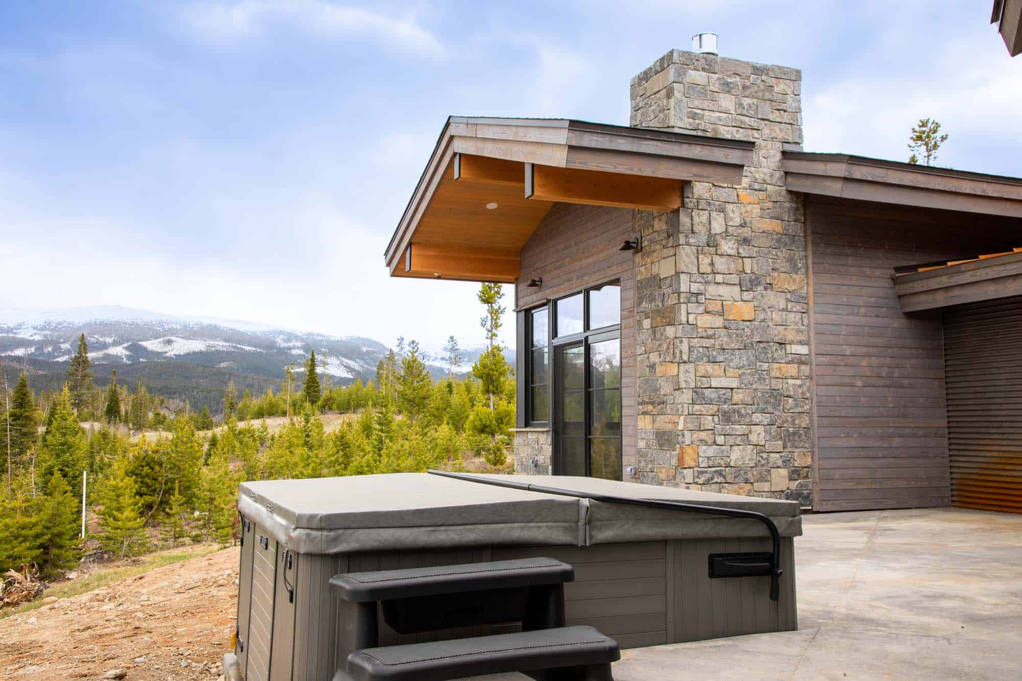 Exterior view of a modern mountain lodge with stone and wood architecture at Devil's Thumb Ranch.