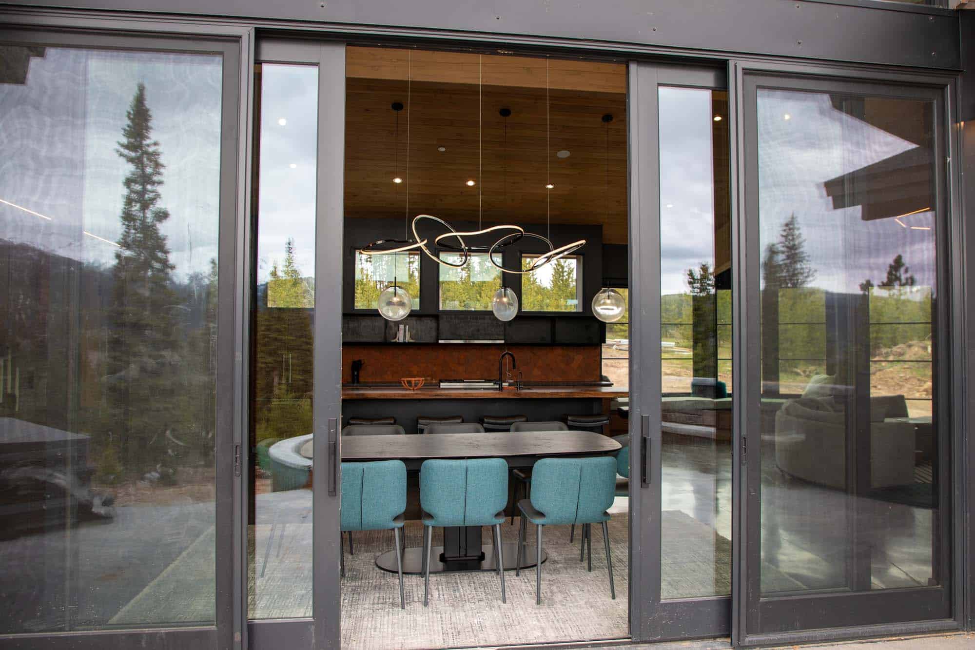 Modern dining area with large glass doors and stylish lighting at Devil's Thumb Ranch.