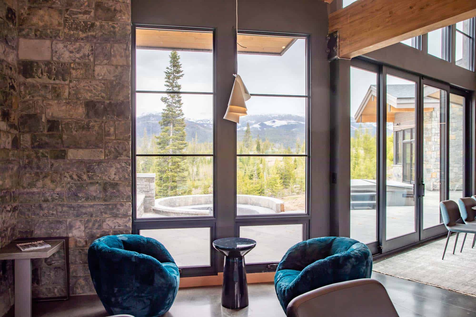Interior view of a cozy lounge area with large windows overlooking mountain scenery.