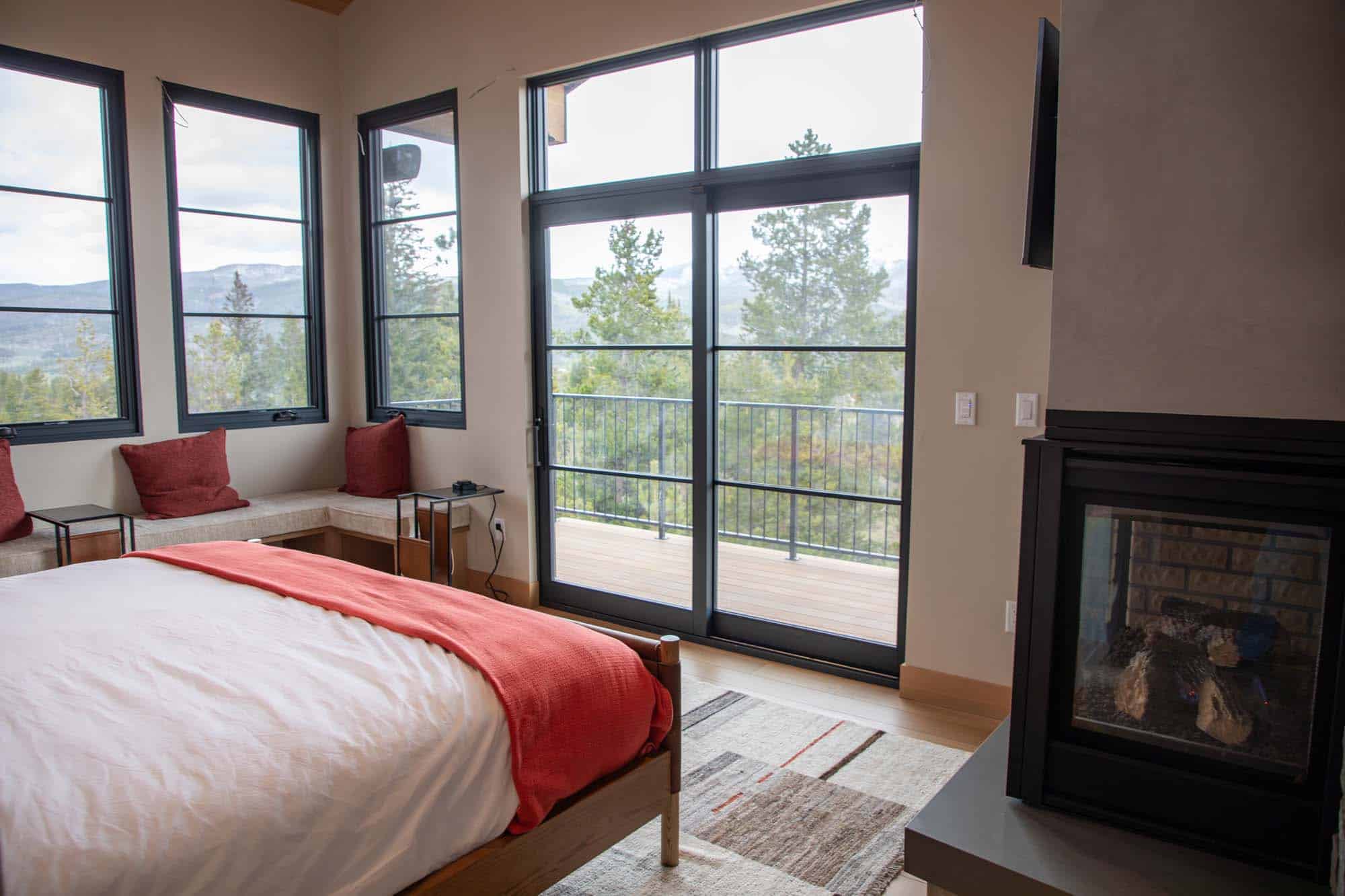 Comfortable bedroom with large windows and mountain views at Devil's Thumb Ranch Resort & Spa.