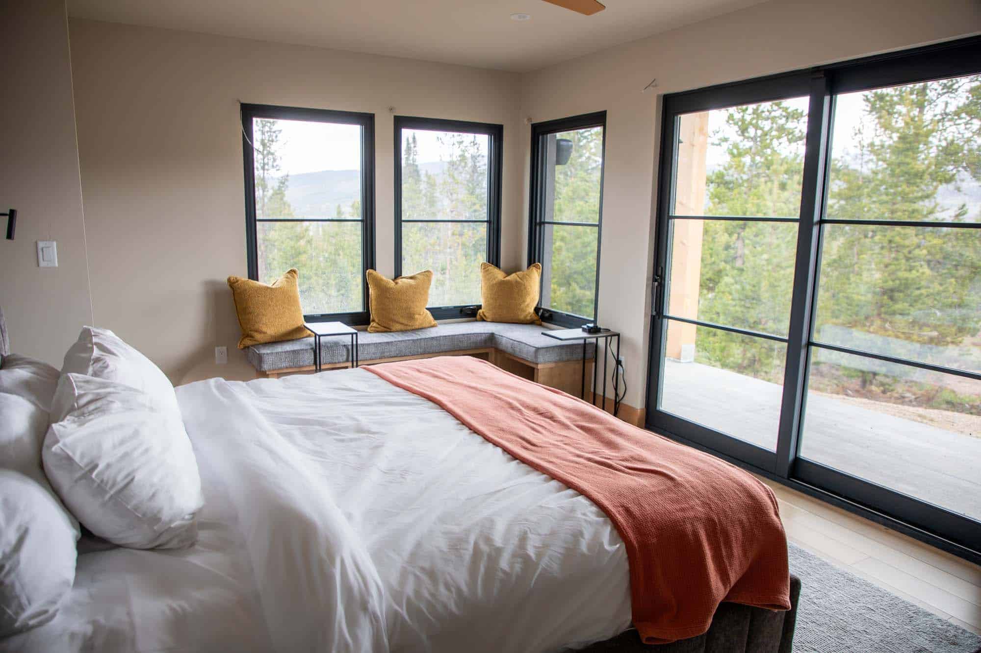 Cozy bedroom with large windows and mountain views at Devil's Thumb Ranch.