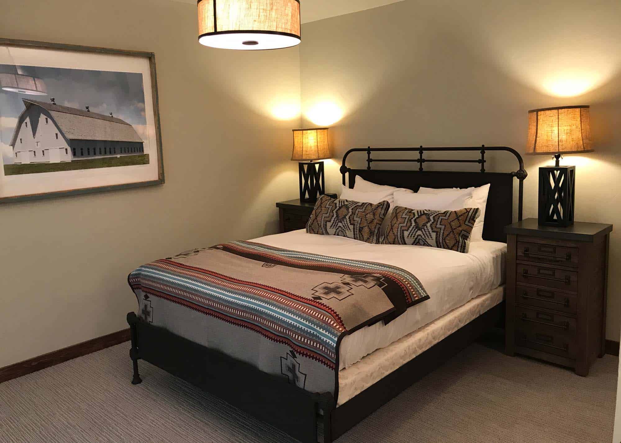 Cozy bedroom at Devil's Thumb Ranch with a comfortable bed, decorative pillows, and warm lighting.