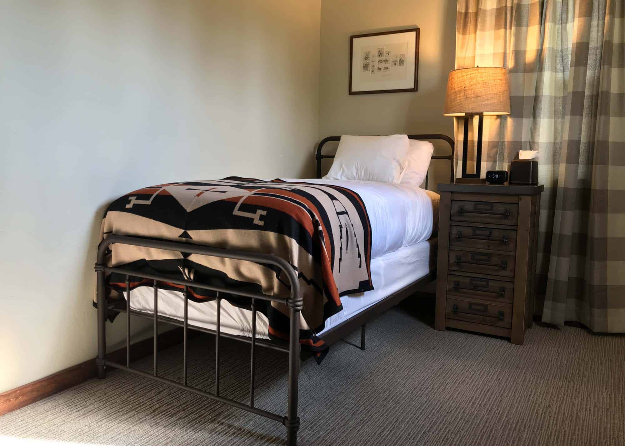 Cozy guest room at Devil's Thumb Ranch with a single bed and warm lighting.