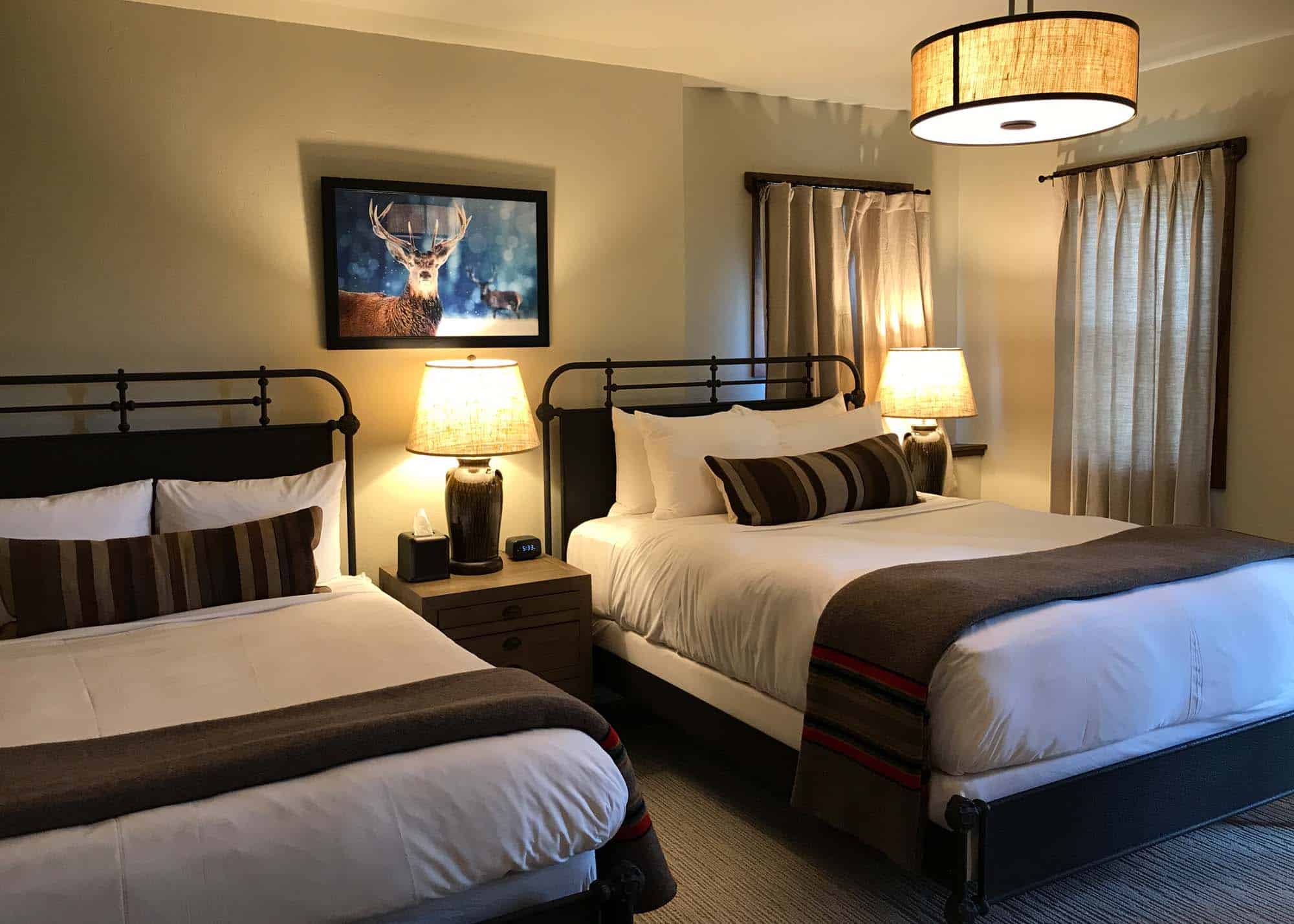 Comfortable hotel room with two beds, warm lighting, and mountain decor at Devil's Thumb Ranch Resor.