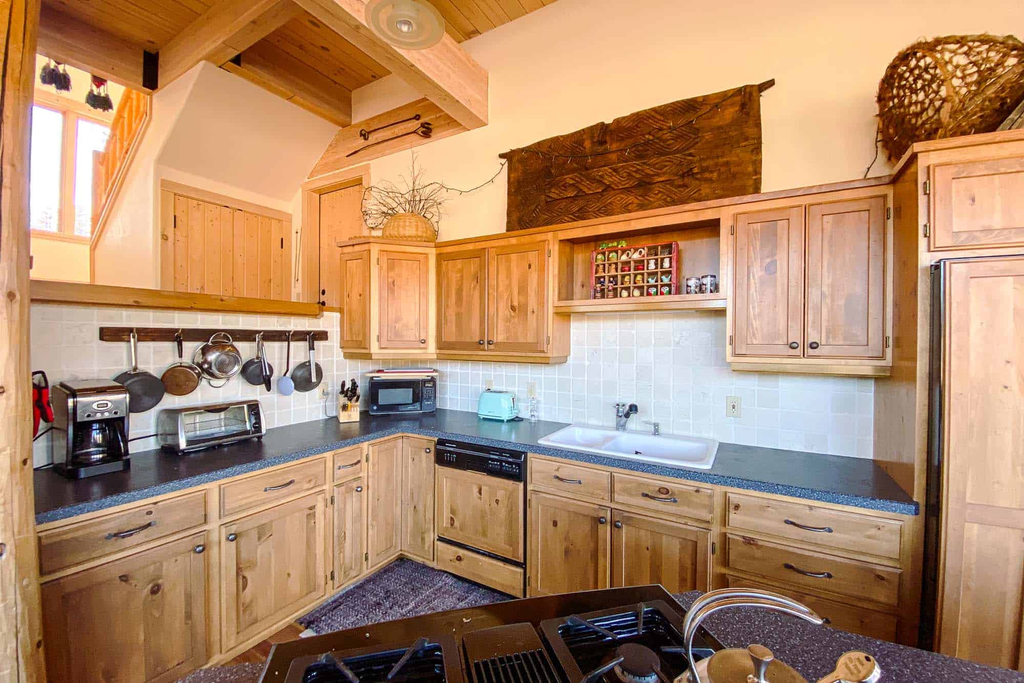 Rustic kitchen with wooden cabinets and modern appliances at Devil's Thumb Ranch.