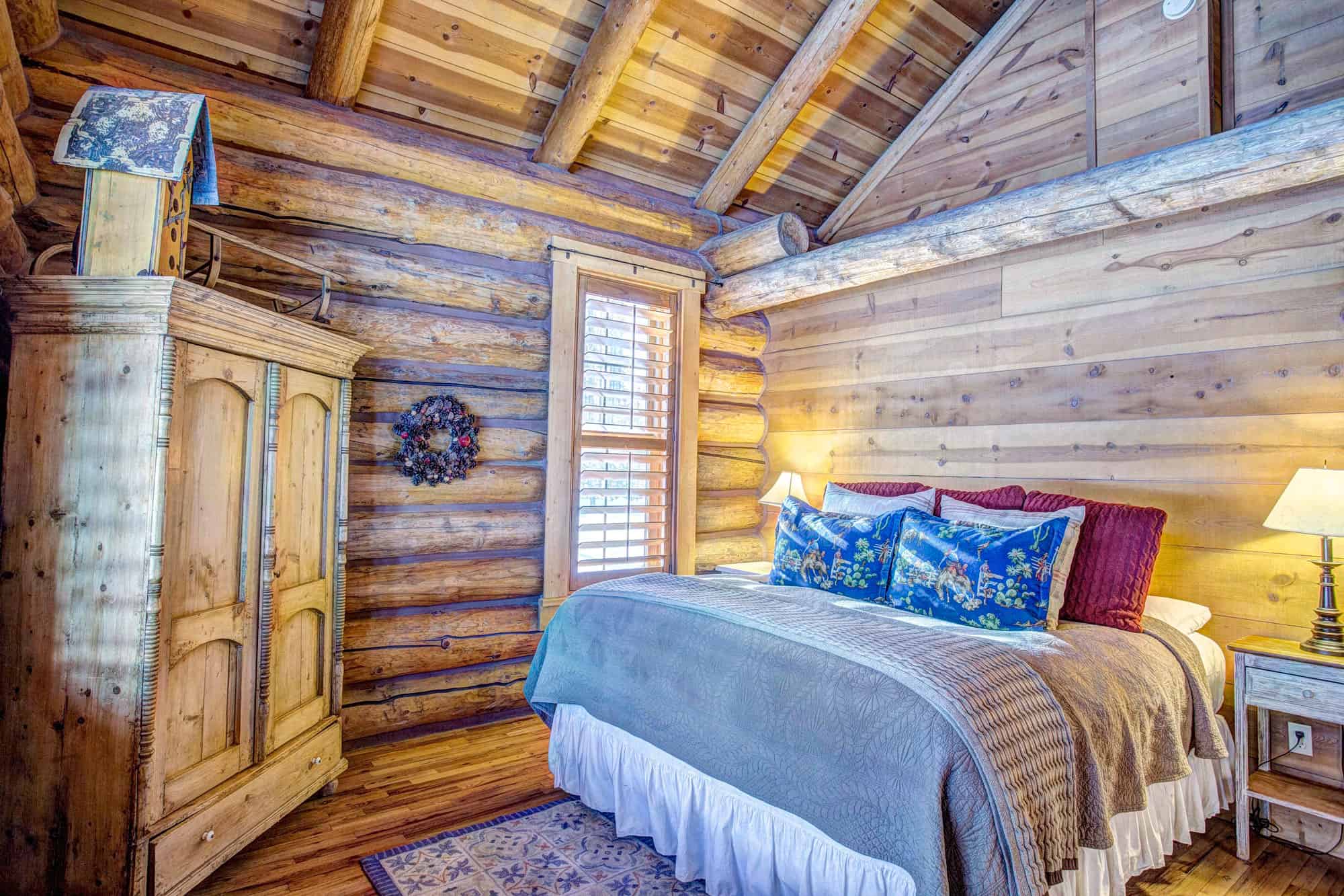 Interior view of a rustic log cabin bedroom at Devil's Thumb Ranch Resort & Spa.