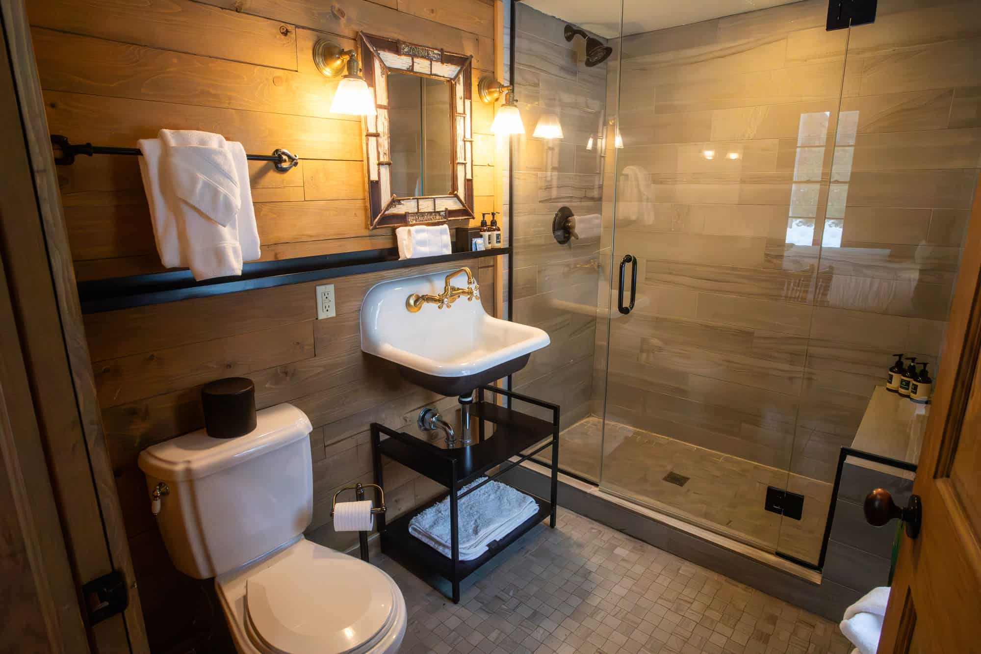 Rustic bathroom with wooden accents, modern fixtures, and a glass shower at Devil's Thumb Ranch.