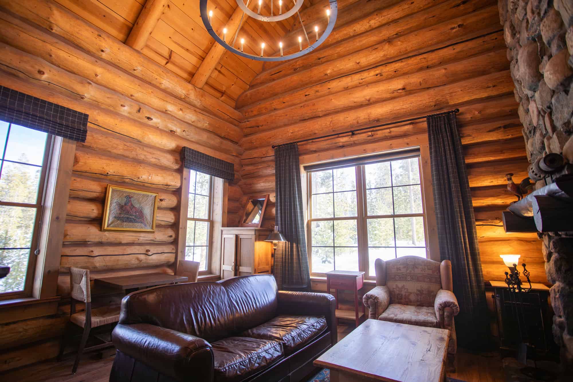 Cozy log cabin living room with leather sofa and rustic decor at Devil's Thumb Ranch.