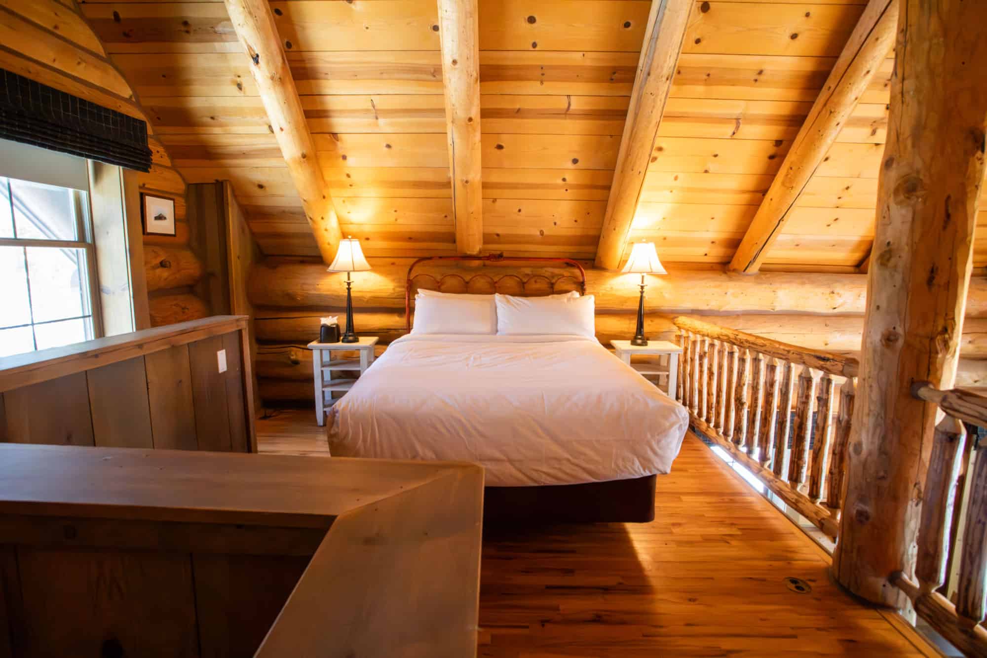 Cozy rustic bedroom with wooden walls and warm lighting at Devil's Thumb Ranch Resort & Spa.