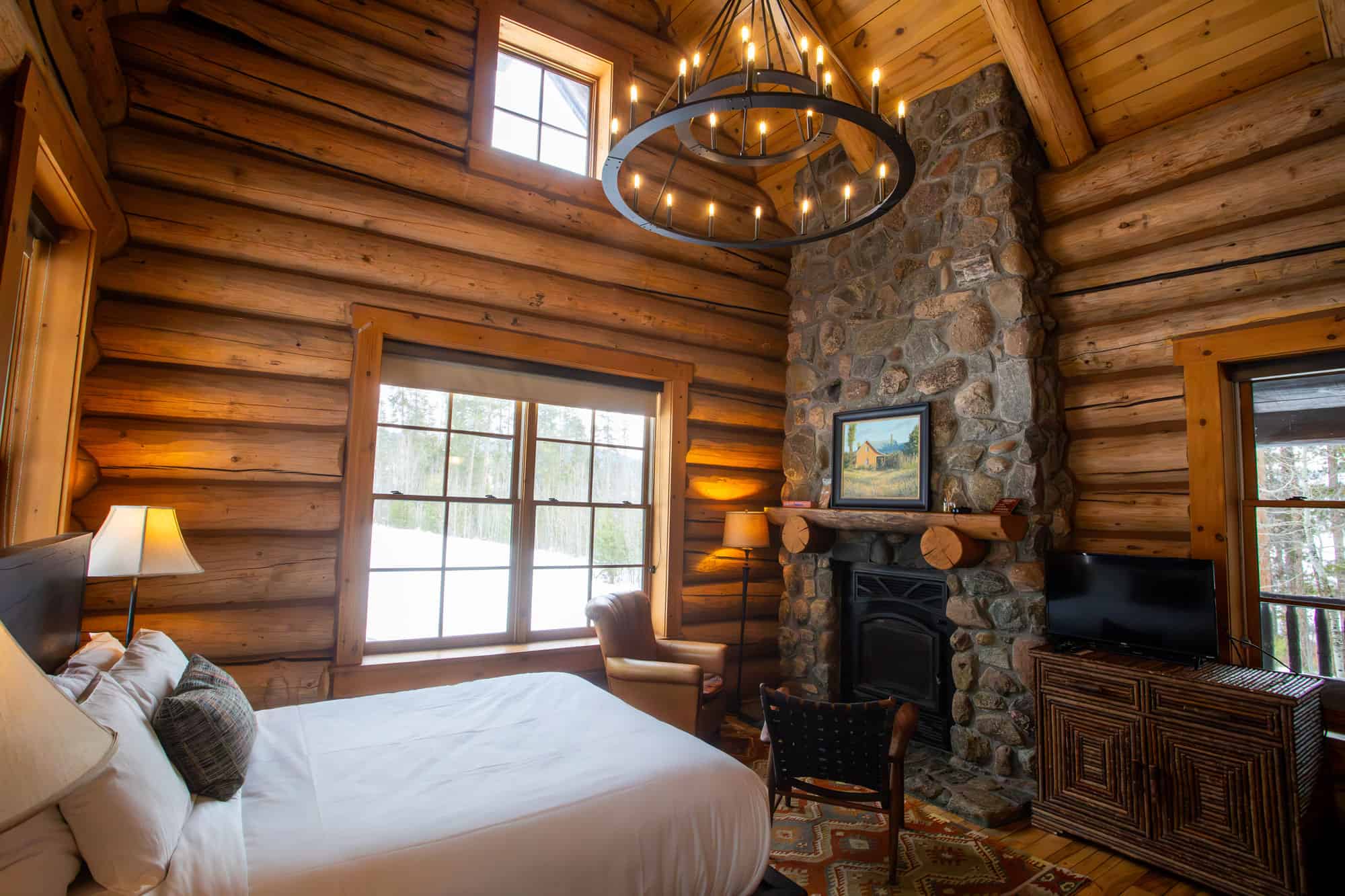 Interior view of a cozy log cabin bedroom at Devil's Thumb Ranch Resort & Spa.