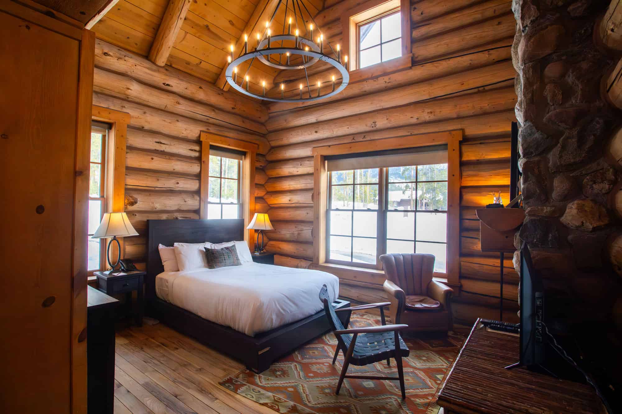 Cozy log cabin bedroom with rustic decor and warm lighting at Devil's Thumb Ranch.
