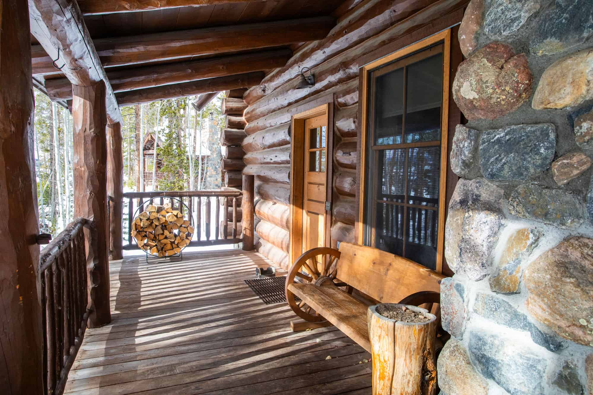 Cozy log cabin porch with wooden bench and stone accents at Devil's Thumb Ranch Resort & Spa. Perfec.