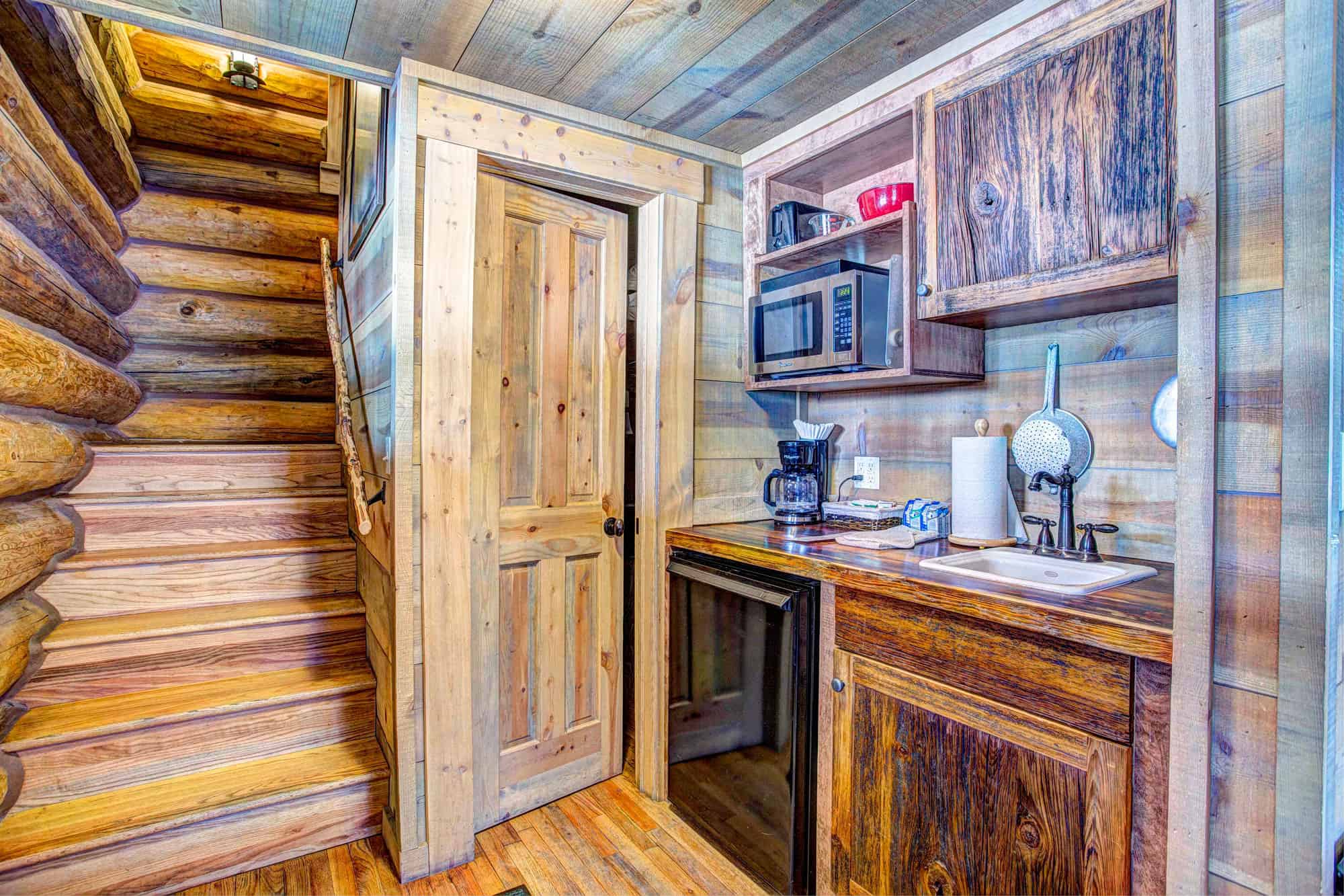 Cozy rustic kitchen with wooden cabinets and appliances at Devil's Thumb Ranch.