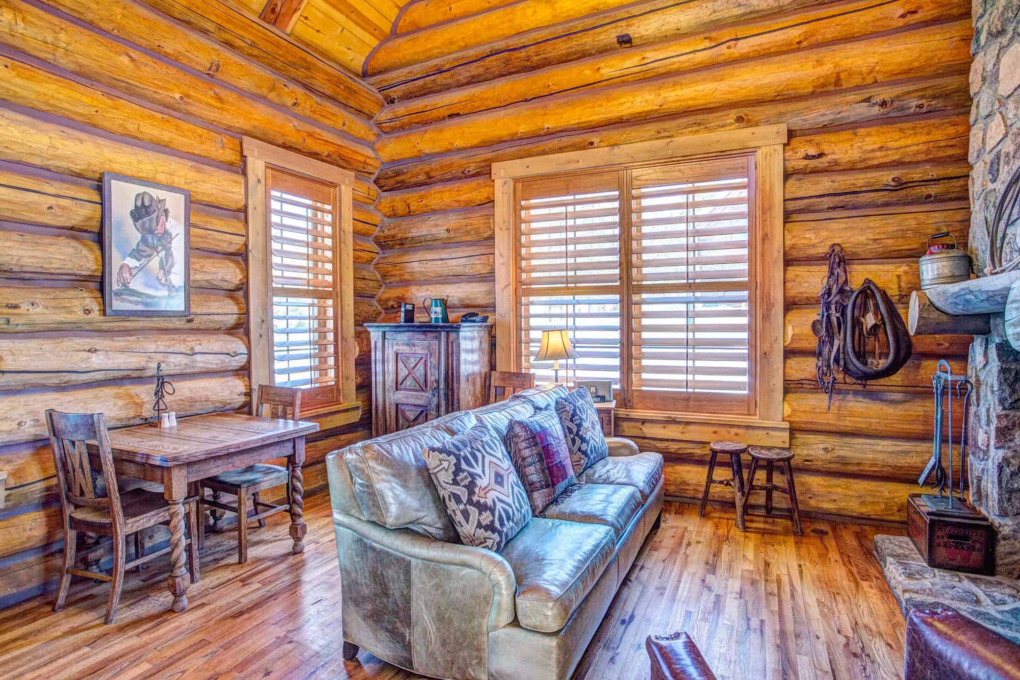 A warm, inviting living room with wooden log walls, a comfortable sofa, and rustic decor at Devil's.