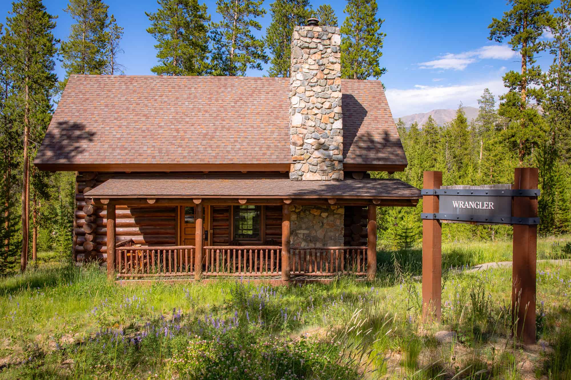 Cabin at Devil's Thumb Ranch with stone chimney and wooden porch.