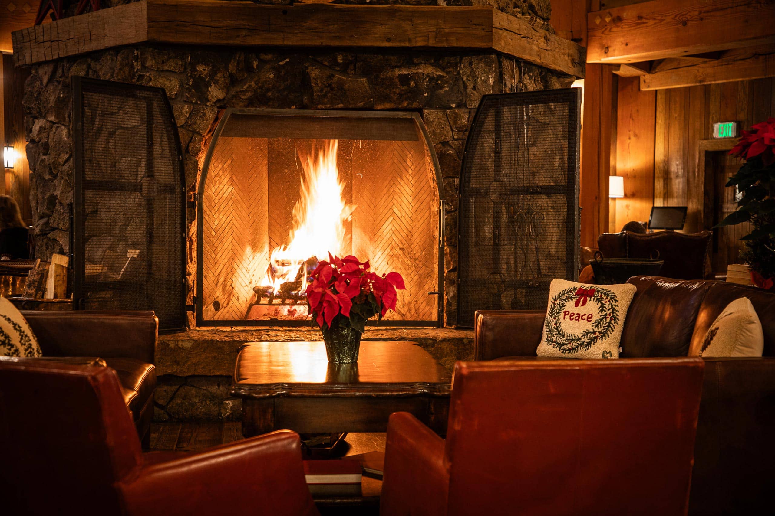 Warm indoor fireplace at Devil's Thumb Ranch Resort & Spa with seating and holiday decor.