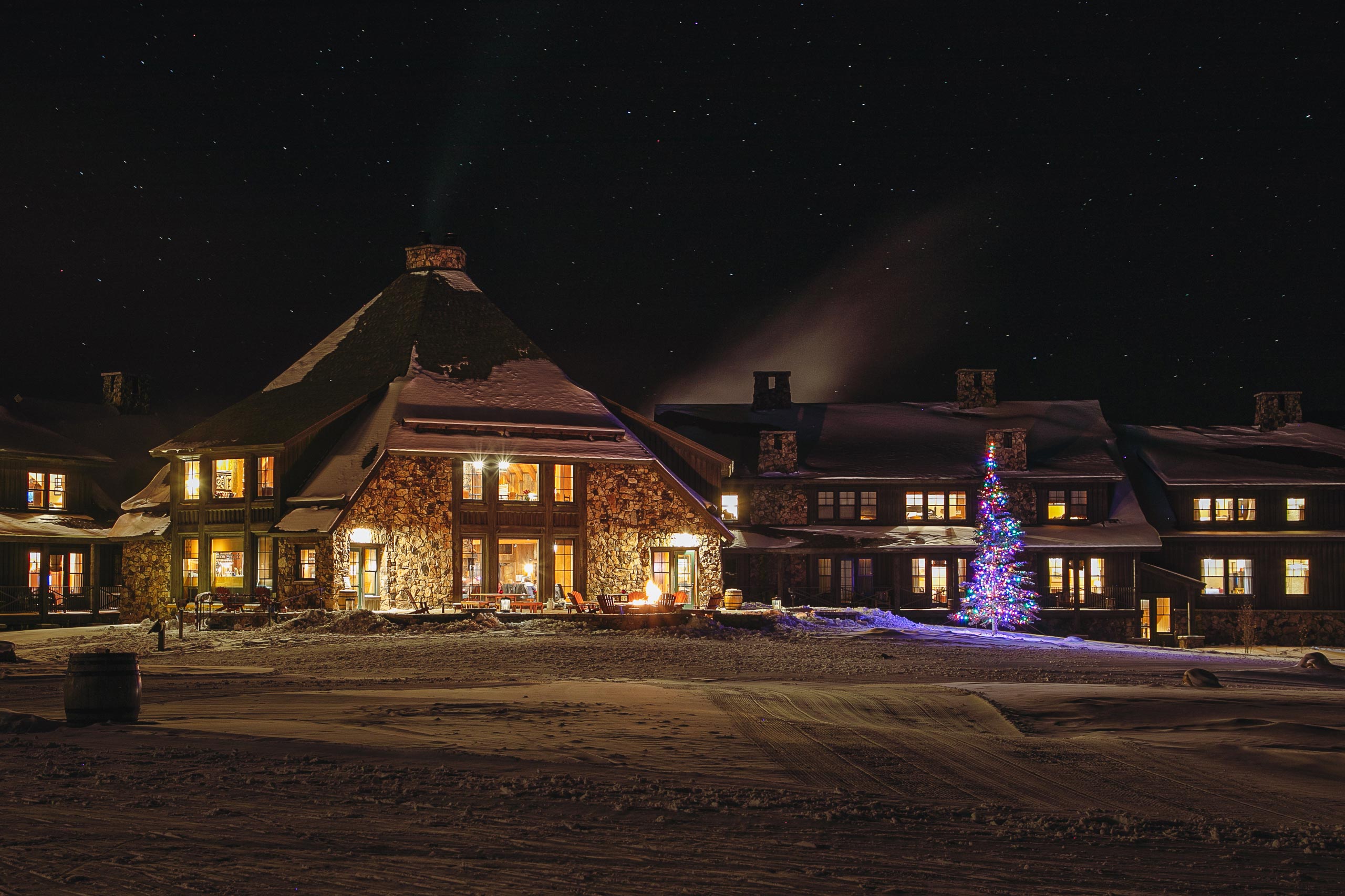 Devil's Thumb Ranch Resort & Spa illuminated at night with a decorated Christmas tree outside.