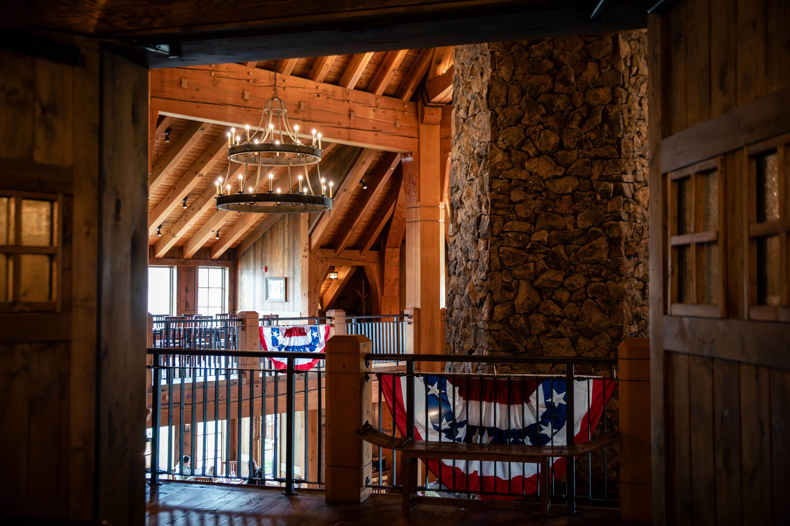 Cozy rustic lodge interior with wooden beams and stone fireplace.