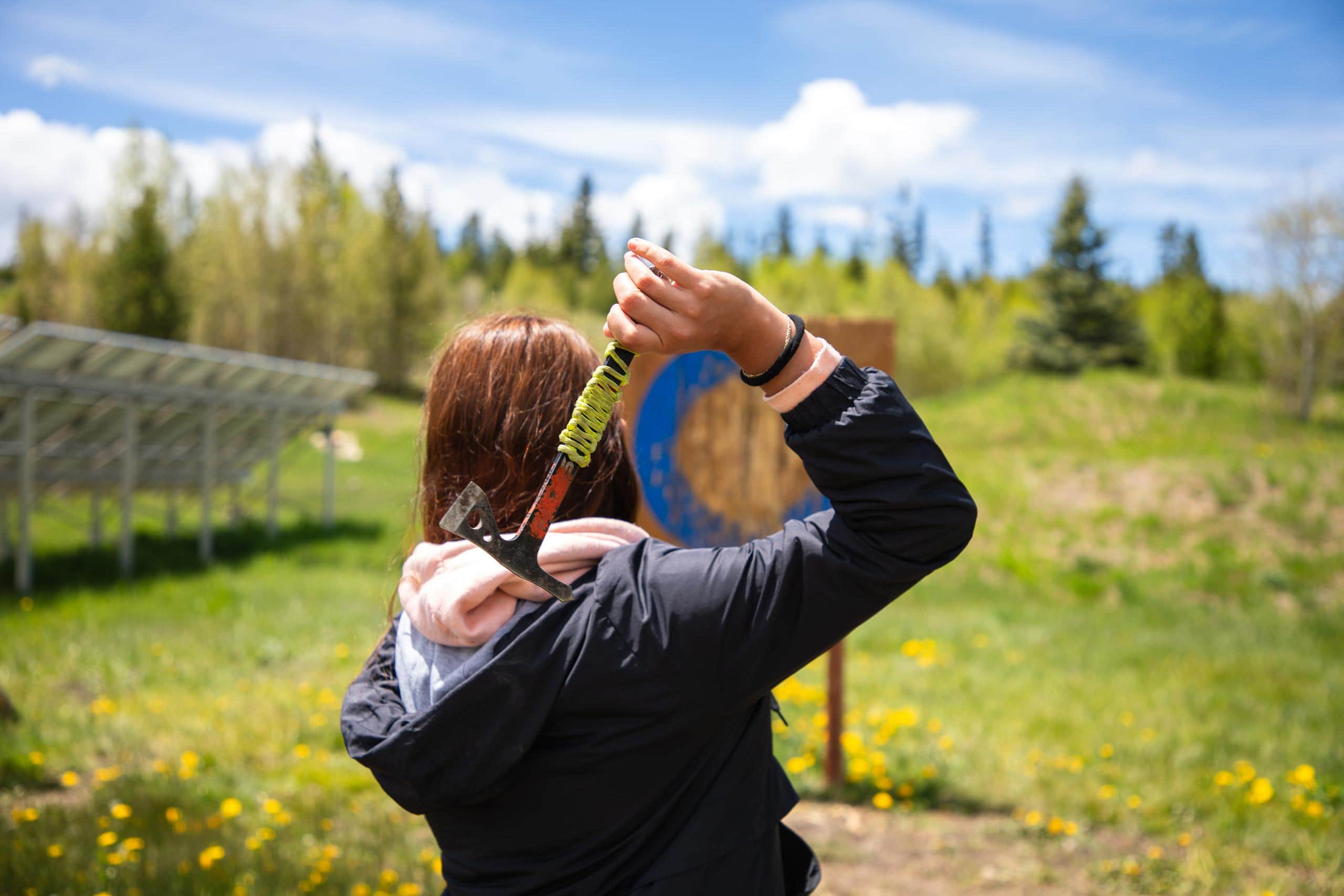 Person with axe in hand at Devil's Thumb Ranch outdoor setting.