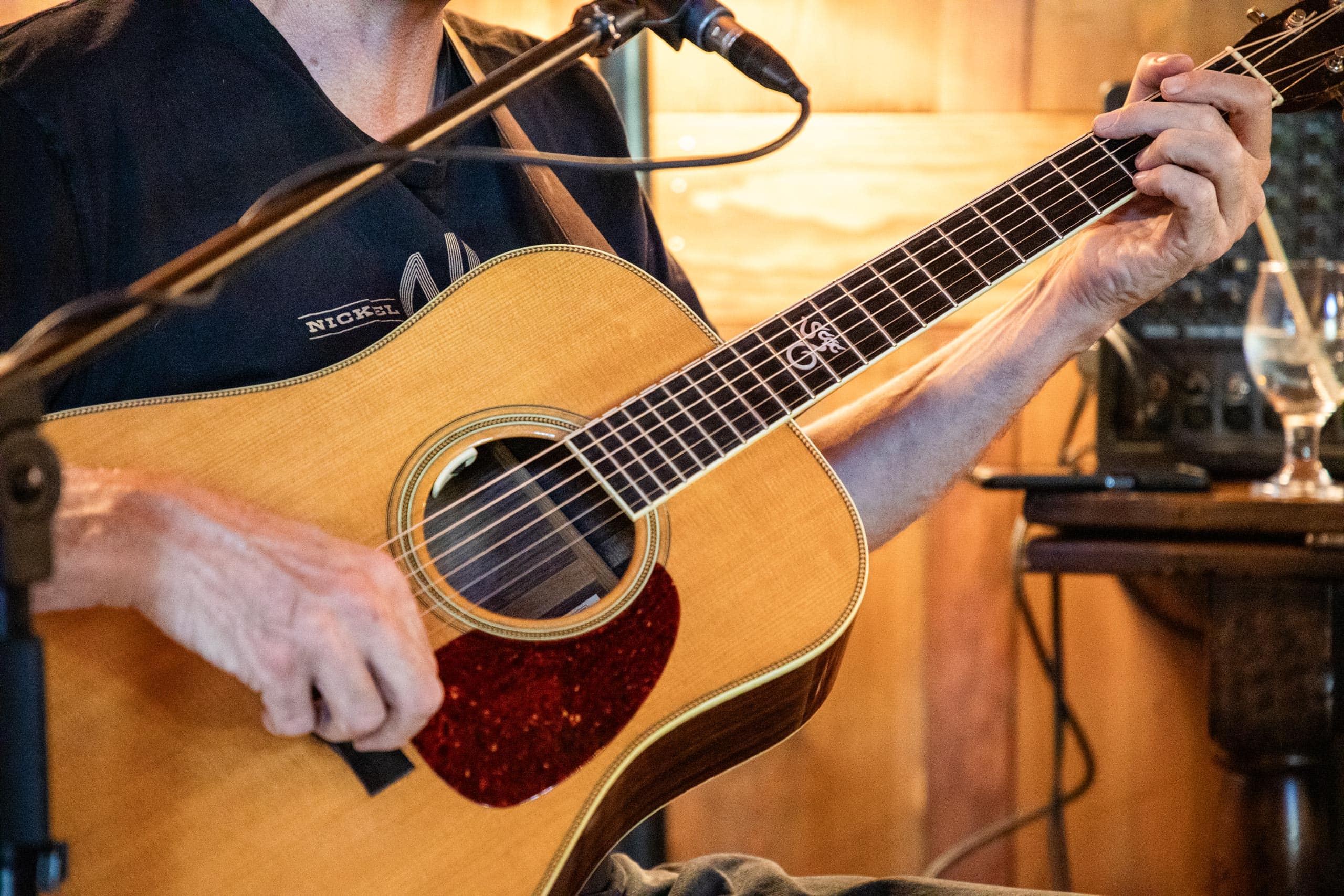 Person playing acoustic guitar at Devil's Thumb Ranch Resort & Spa.