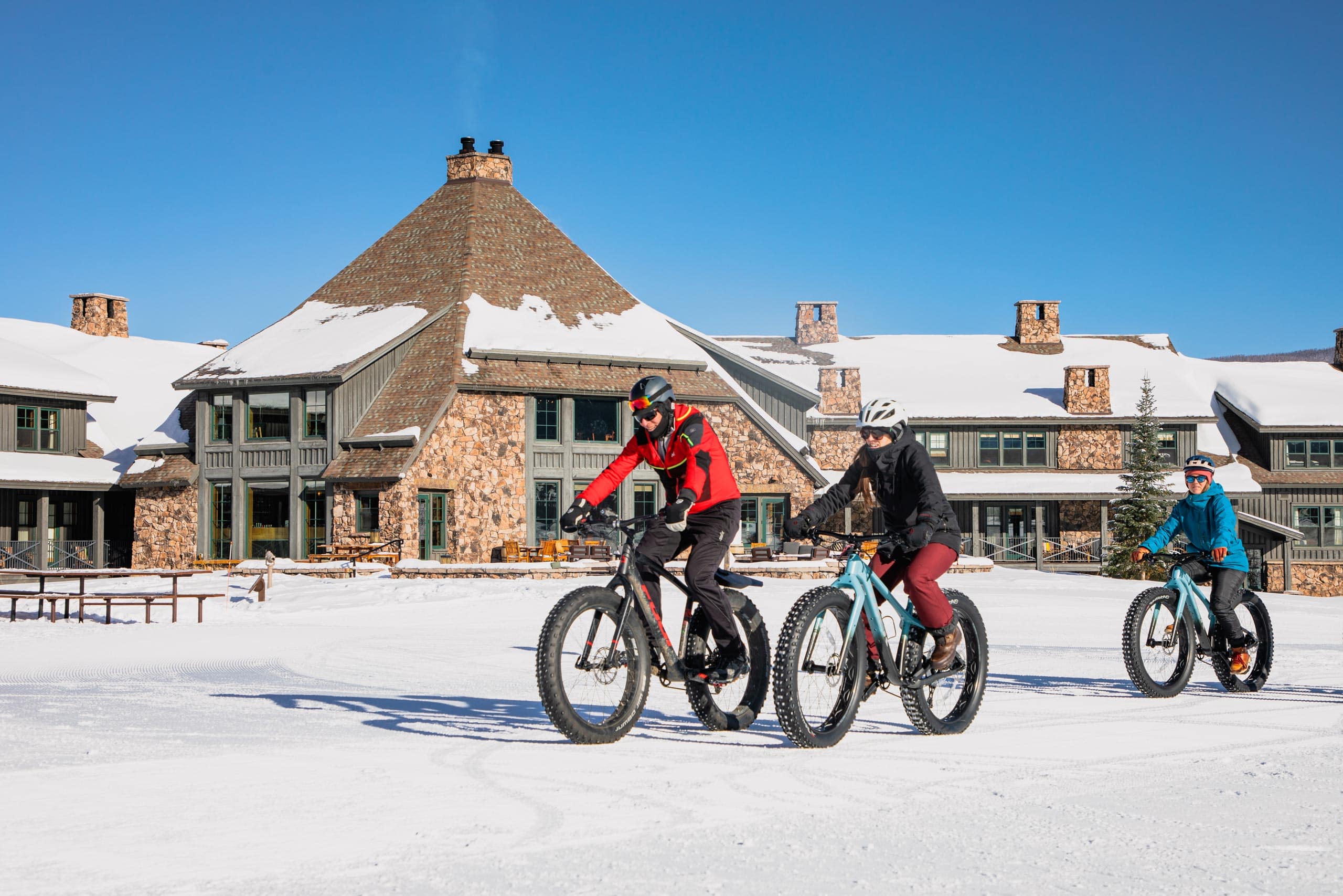 Cyclists riding bikes in snow at Devil's Thumb Ranch Resort & Spa.