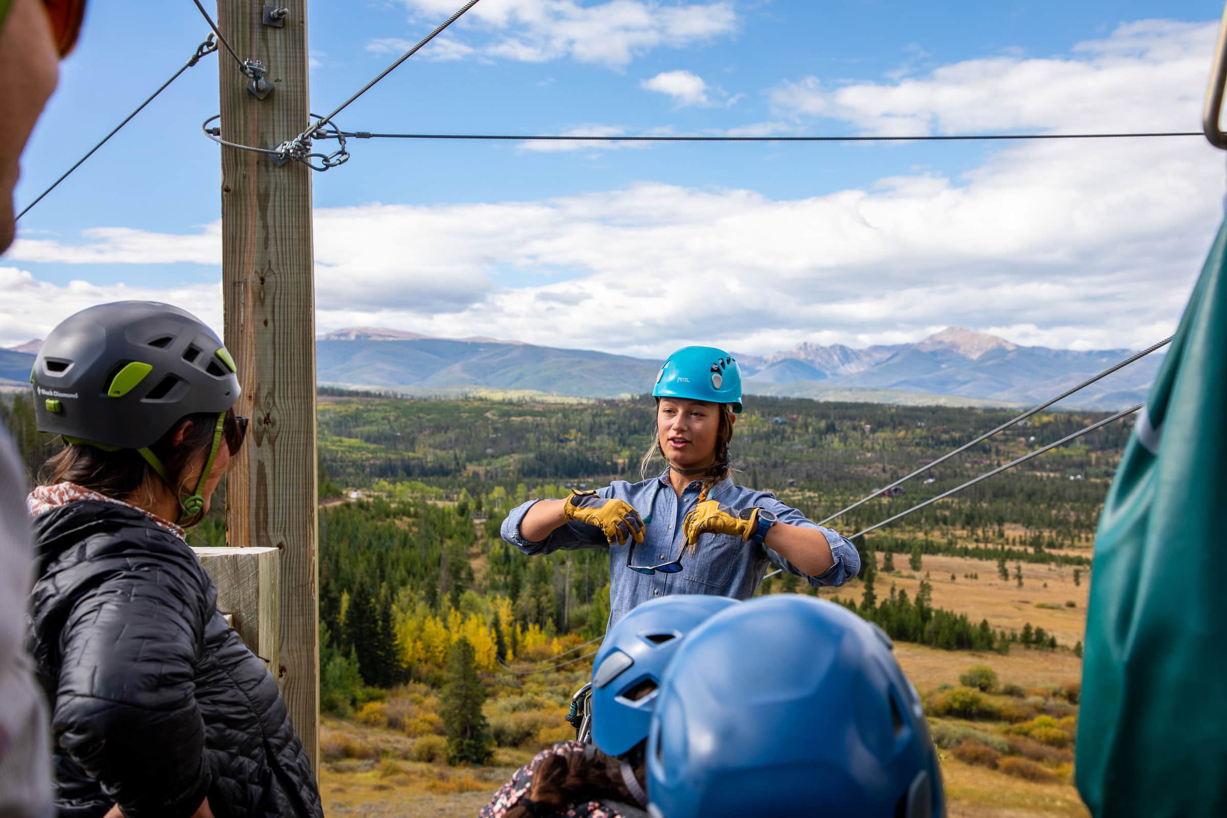Group of people with helmets enjoying zip lining at Devil's Thumb Ranch.