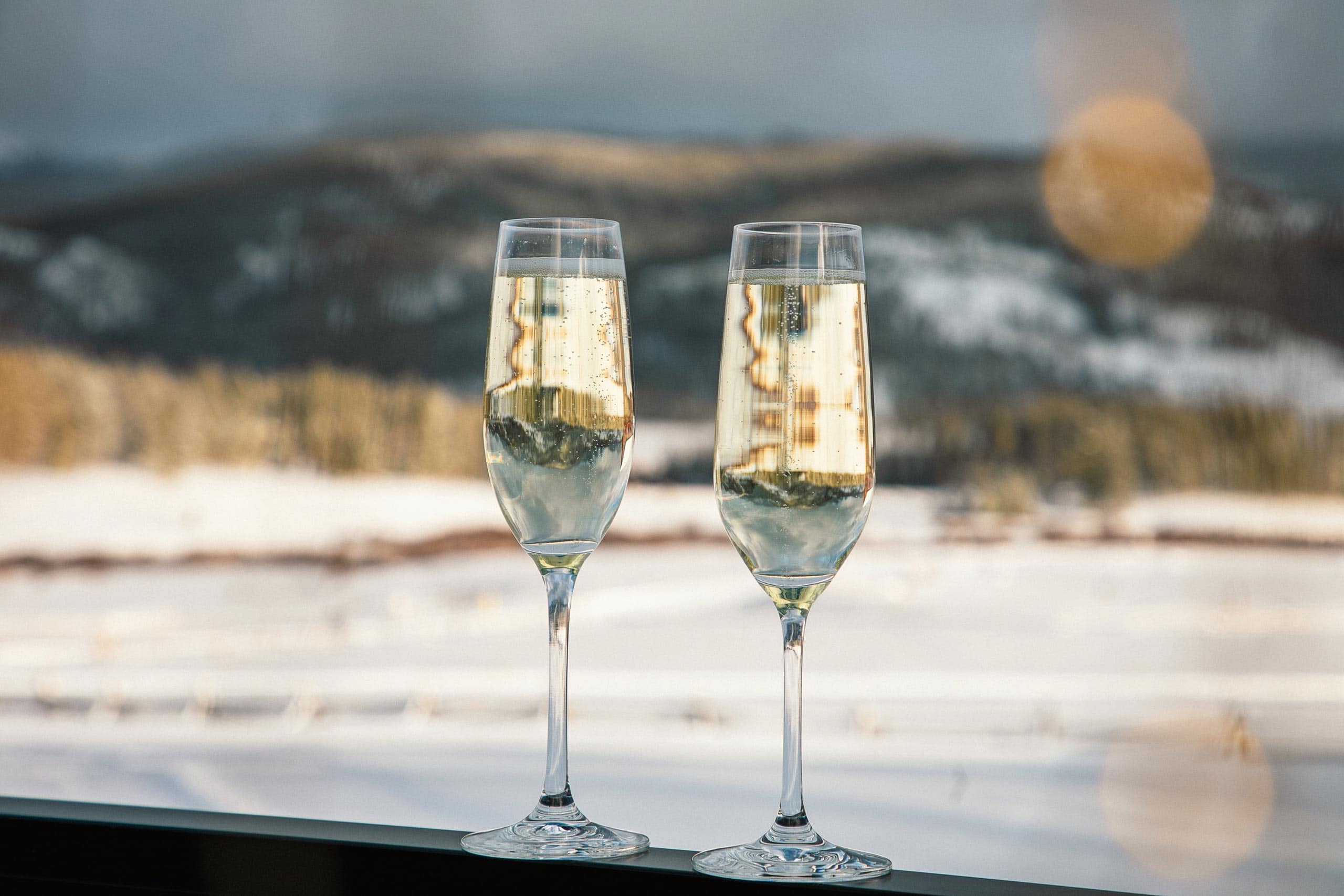 Two glasses of champagne with mountain view at Devil's Thumb Ranch.