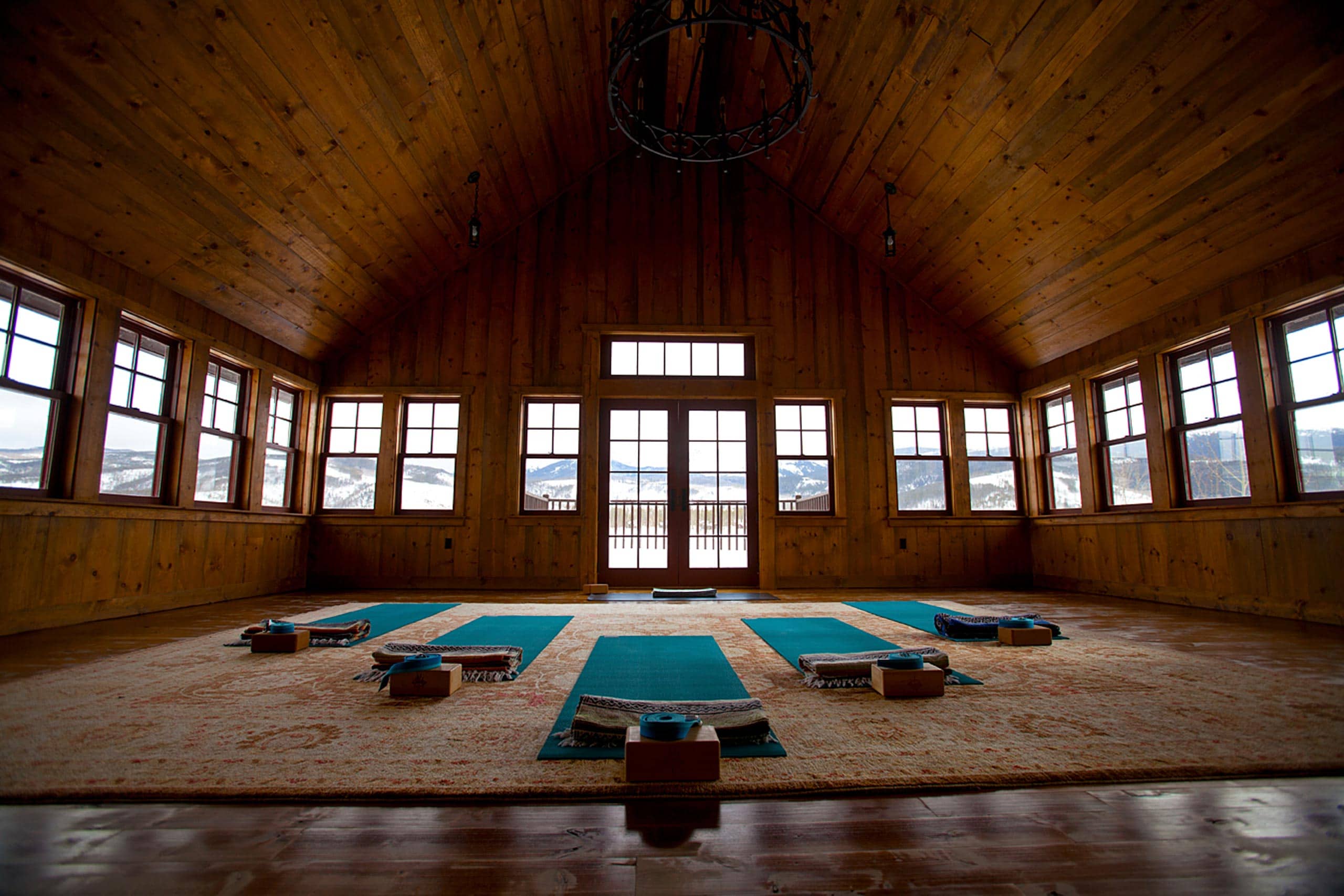 Serene yoga studio at Devil's Thumb Ranch with wooden interior and large windows.