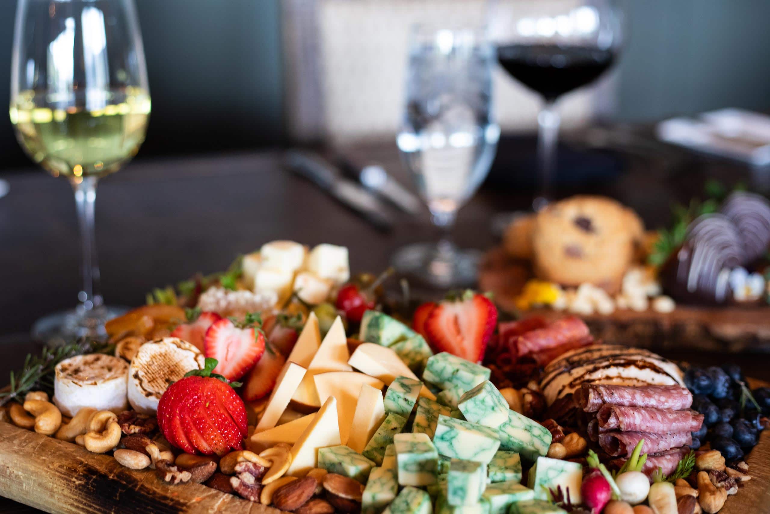 Gourmet cheese platter with strawberries, nuts, and wine at Devil's Thumb Ranch.