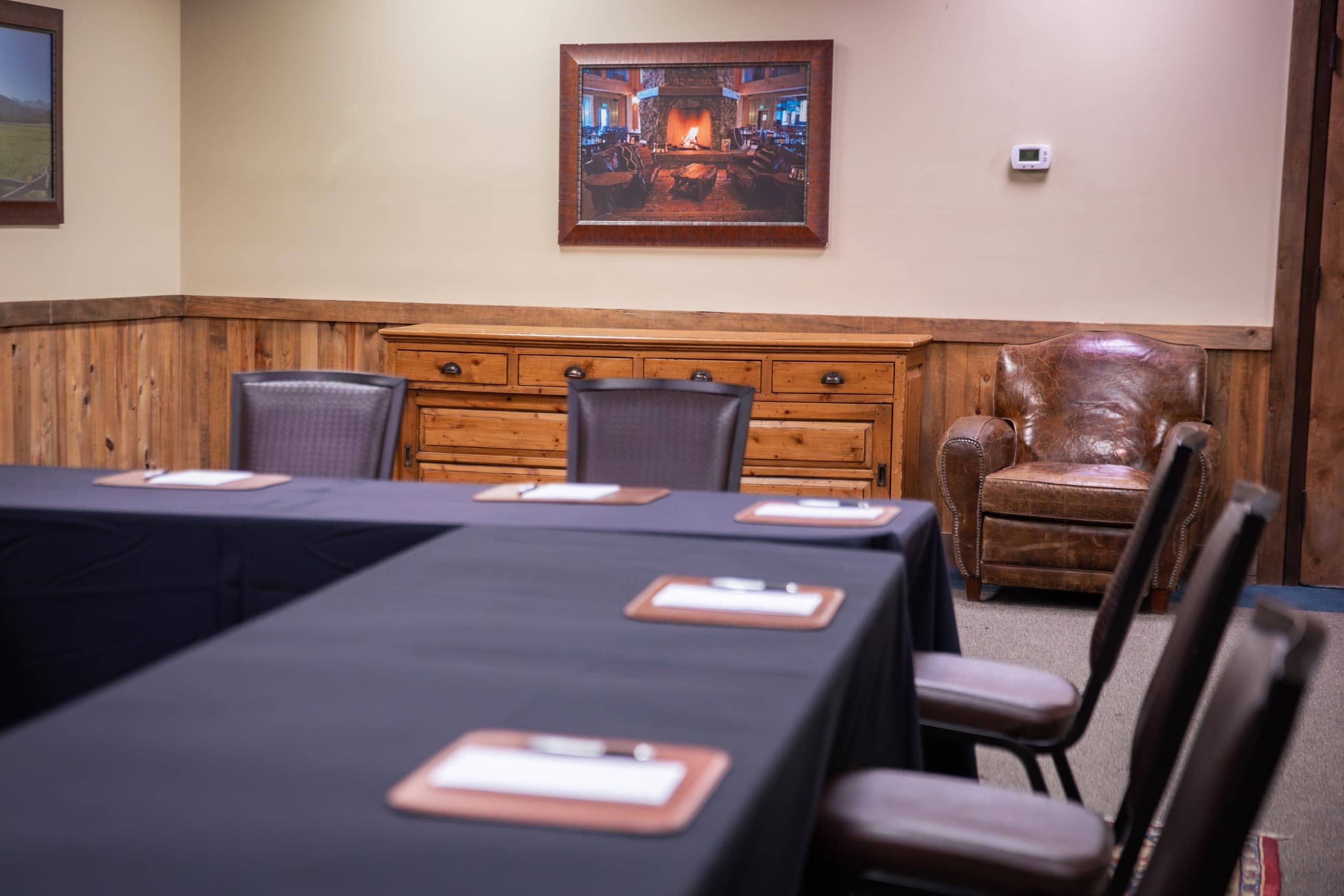 Cozy meeting room at Devil's Thumb Ranch with wood accents and fireplace art.