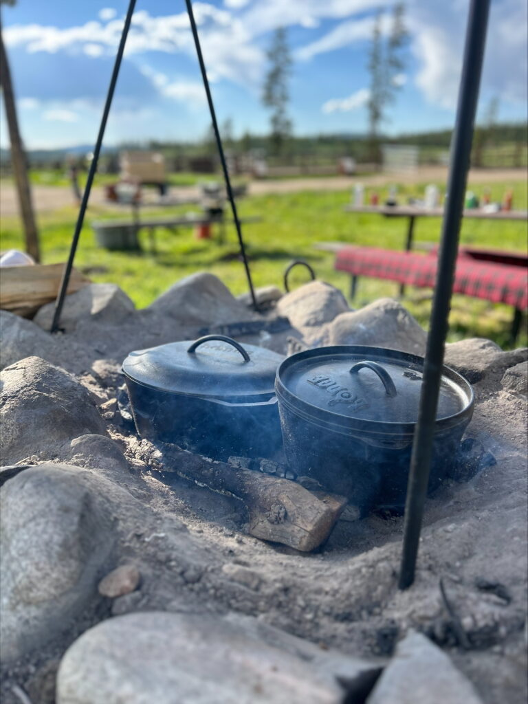 Cast iron pots cook over an outdoor campfire